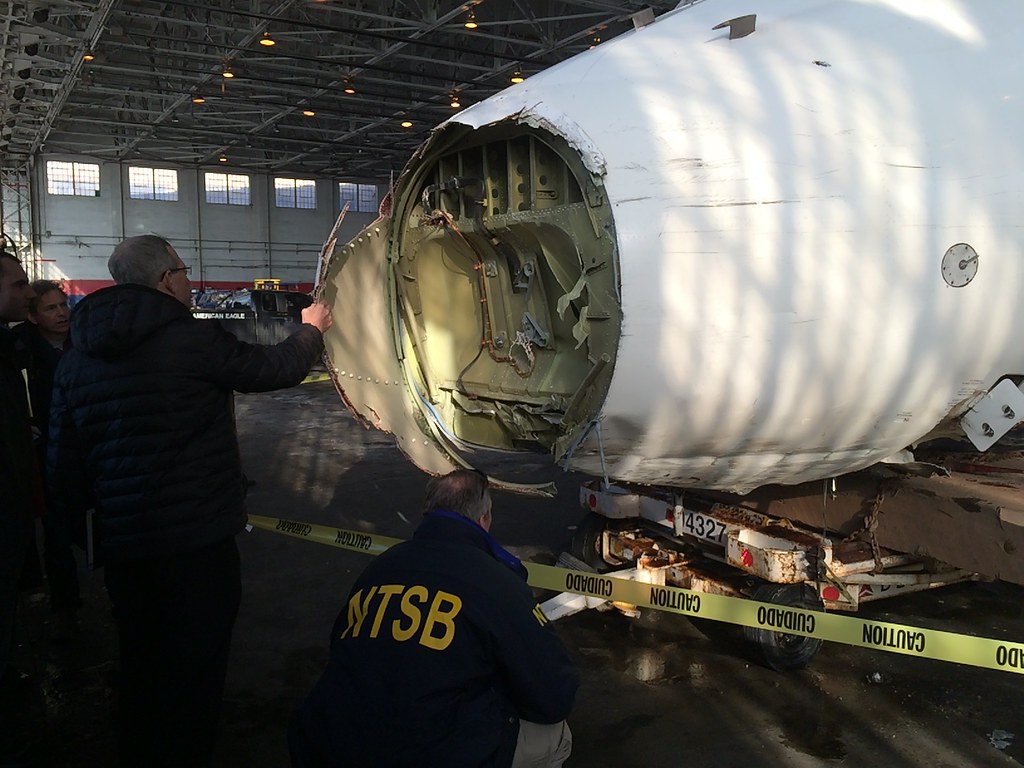 NTSB investigators examining the nose gear area of Delta flight 1086 that skidded of the runway at LaGuardia Airport.